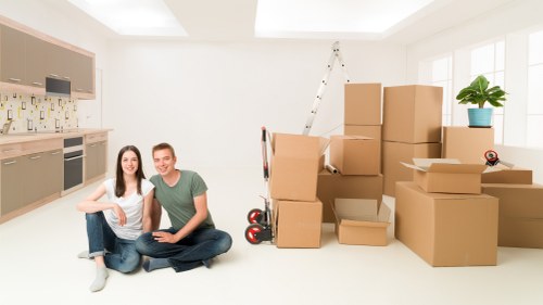 Mover carrying furniture through a residential property in Hanwell